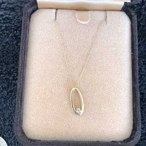 Necklace gold color oval pendant with small clear stone.  Meyers Jewelers.